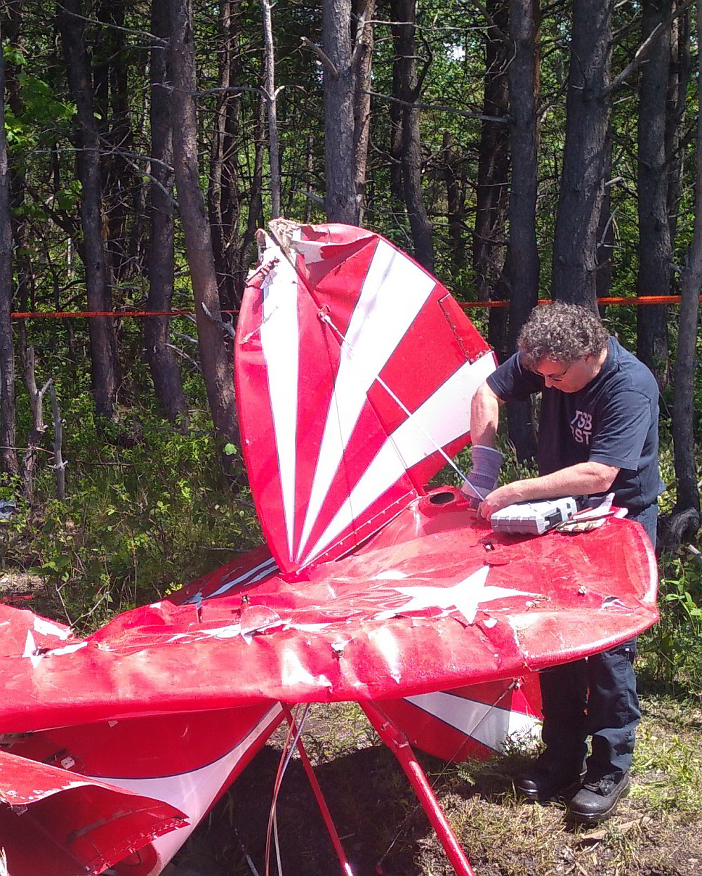 Un enquêteur du BST examine l'épave d'un avion de type Pitts S2E après un accident à Saint-Jean-Port-Joli (Québec)