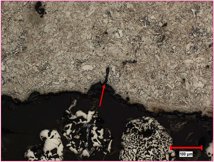 Image micrographie d'une fissure sur le rayon intérieur de la mâchoire d'attelage de la locomotive, à côté de la fissure de fatigue