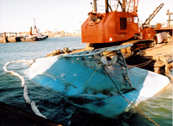 Le Cap Rouge II chaviré, reposant le long d'un chaland de sauvetage. 15 août 2002
