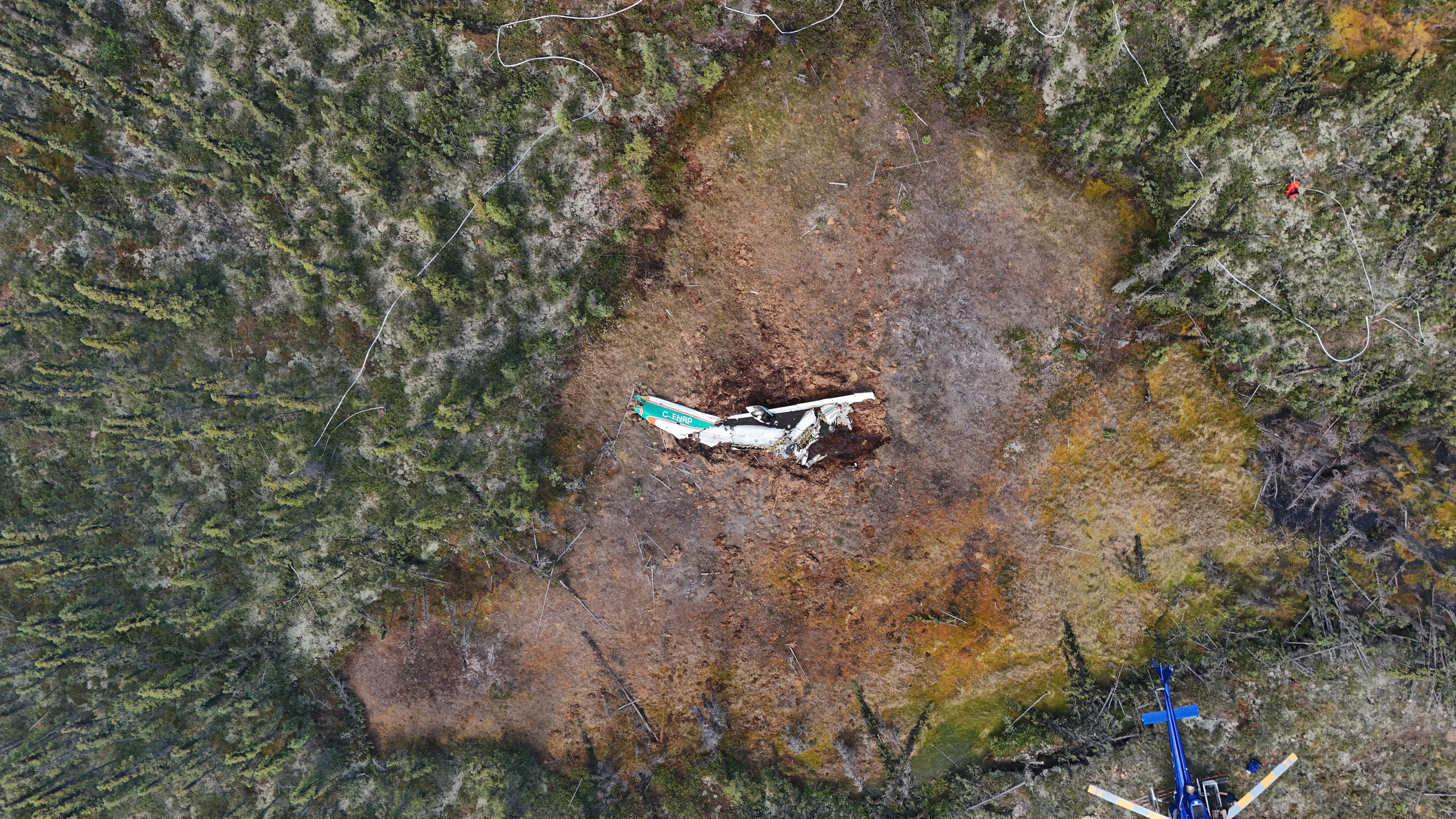 Photo 1: Aerial view of the wreckage following the 24 June 2026 in-flight breakup and collision with terrain near Fort Simpson Airport, Northwest Territories (Source: Transportation Safety Board of Canada)